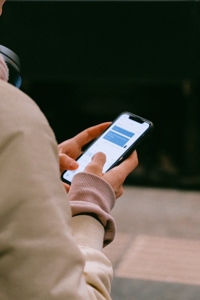 creative A person using a smartphone for texting, focusing on their hands and device screen.