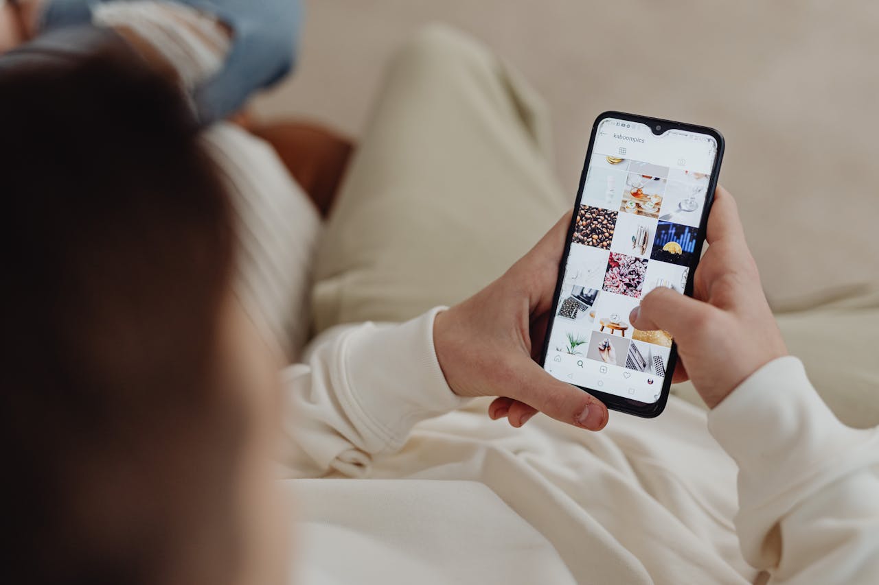 digital Person using smartphone to browse Instagram indoors, showing social media engagement.